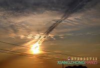 2011.8.19日下午18点，一架喷气飞机划过太阳，留下绚丽的云彩